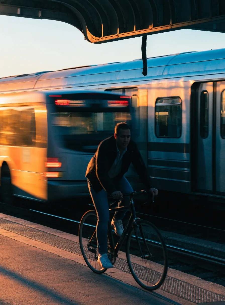 Reisender vor einem Liniennetz-Plan an einer Bahnhofswand am frühen Morgen