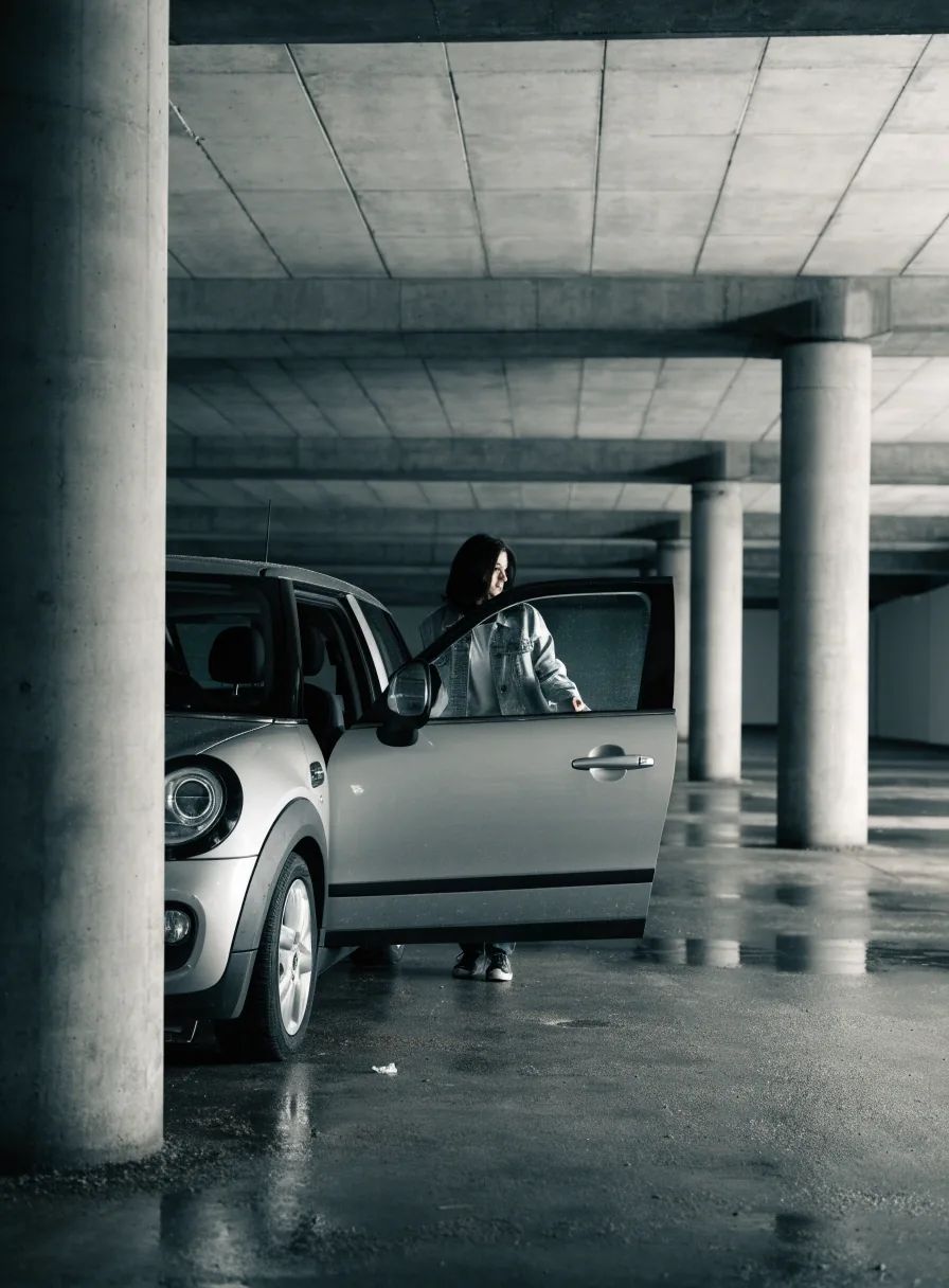 Einfahrt in eine städtische Parkgarage mit Rampe und wartendem Fahrzeug