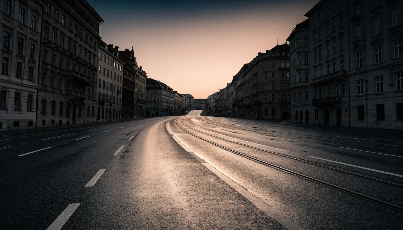 Leere Stadtstraße in Wien in den frühen Morgenstunden mit Fahrspuren und Straßenbahnschienen